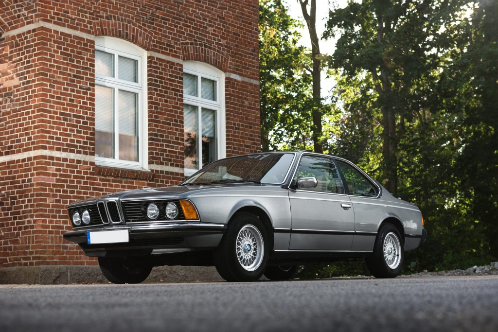 BMW 635 CSI - tidlös design mot tegelvägg, proffsfoto av Runbox Sweden AB, bilauktion och export.