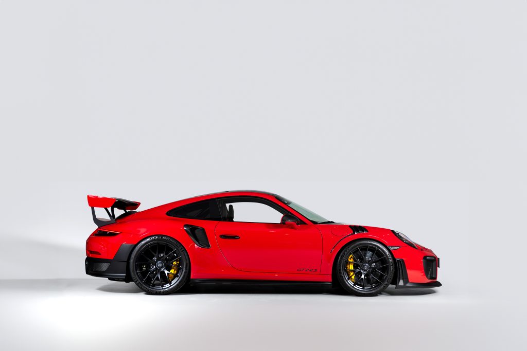 Röd Porsche GT2 fotograferad i studio, perfekt för auktion och bilentusiaster.