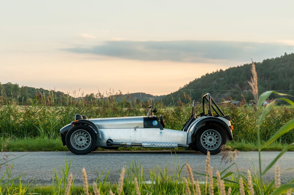 Super Seven parkerad på en landsväg med bakgrund av natursköna vyer