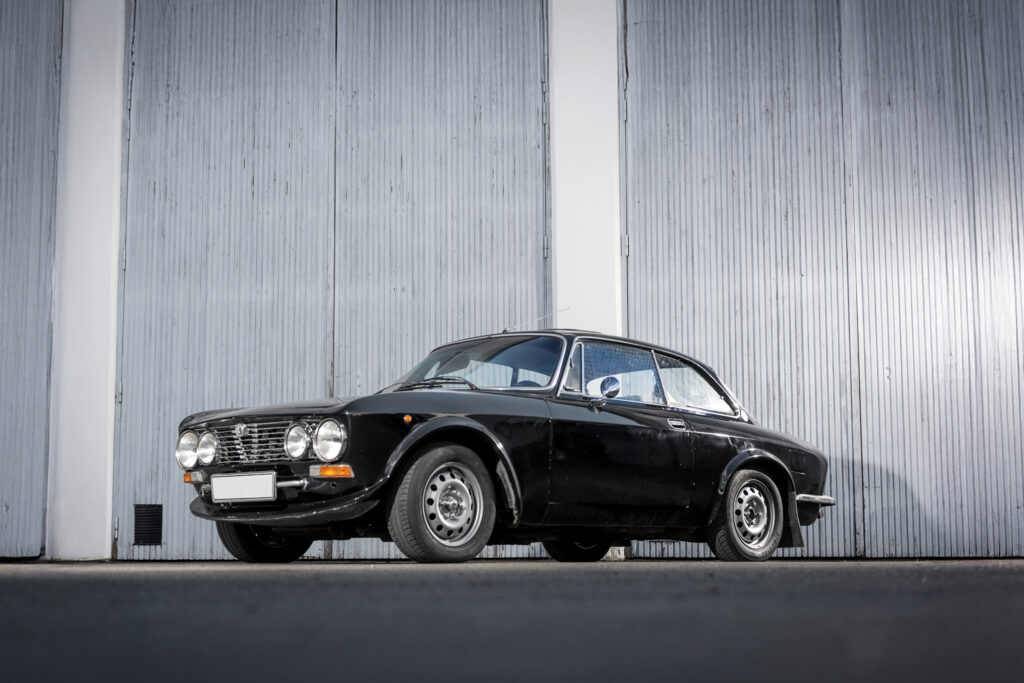 Alfa Romeo GTV 2000 från 1973 i svart lackering – Snygg sidoprofil med ikoniska linjer. Perfekt för samlare och bilentusiaster.