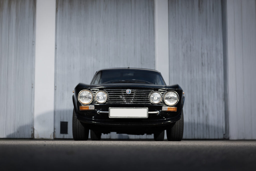 Frontvy av Alfa Romeo GTV 2000 från 1973 med klassiska dubbla strålkastare och sportig grill. Perfekt samlarbil till salu.